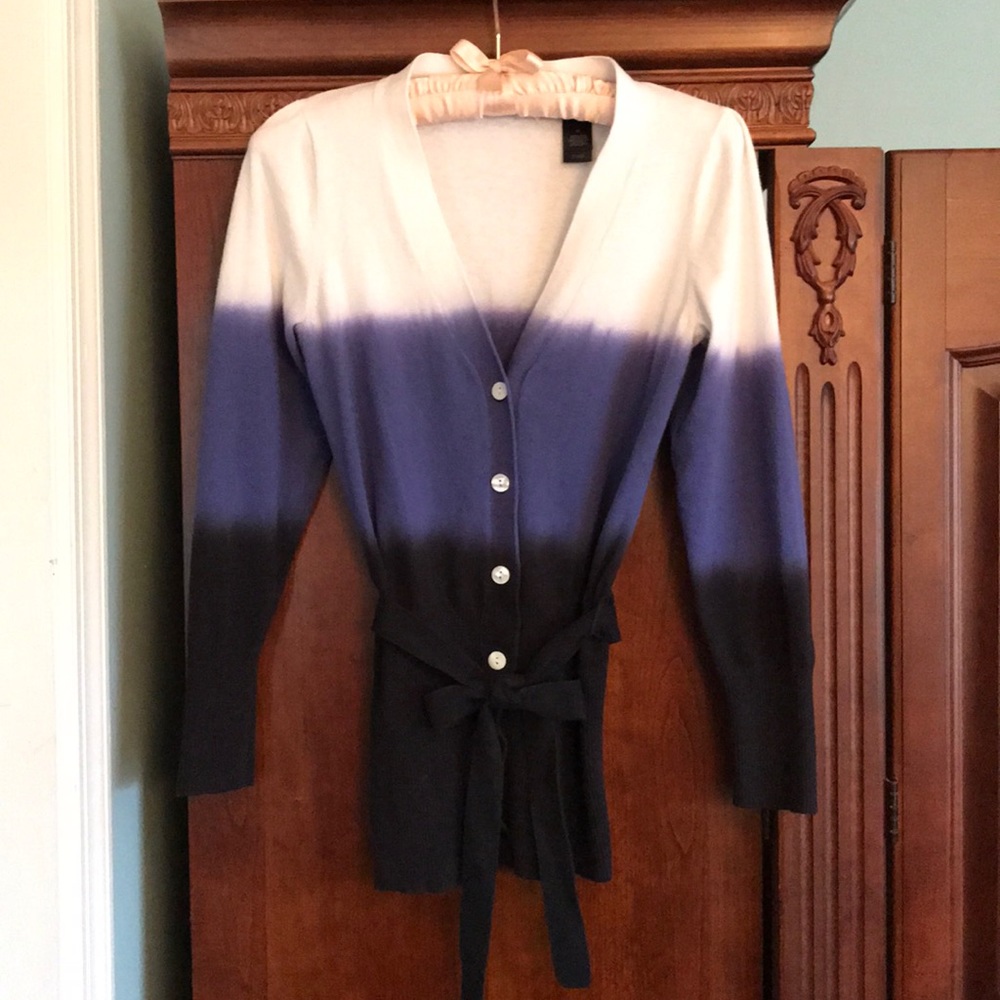 White, blue and black button up sweater.
